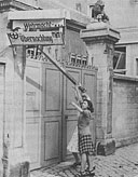 Liberated. French girls knock down German headquarters sign
